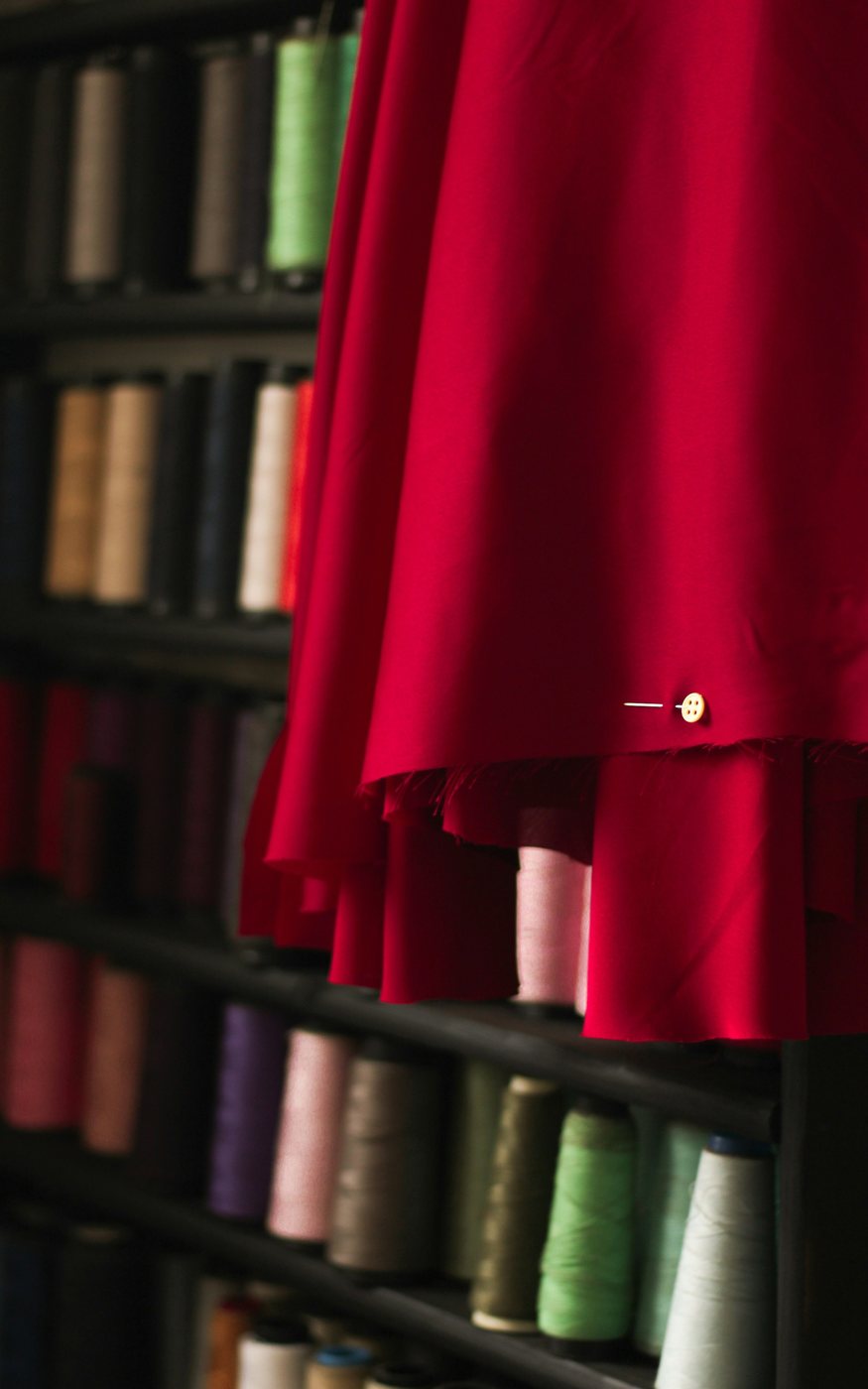 Spools of thread in many colours on a wooden rack