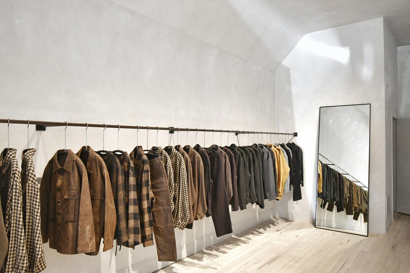 A wall of clothes on shelves and rails in a shop